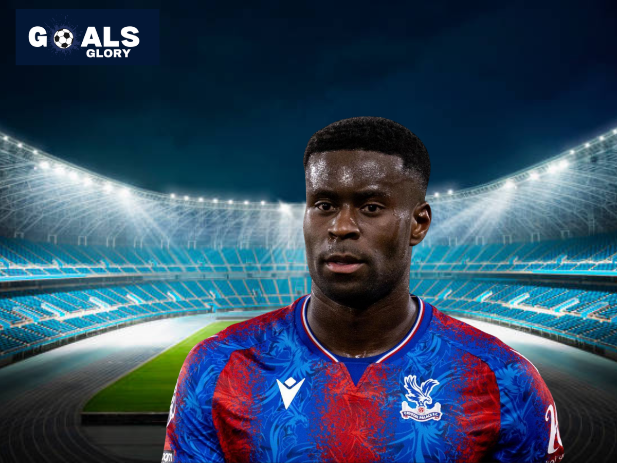 Crystal Palace defender Marc Guehi in the club's red and blue home kit, standing in front of a brightly lit football stadium with a "Goals Glory" logo in the top left corner.