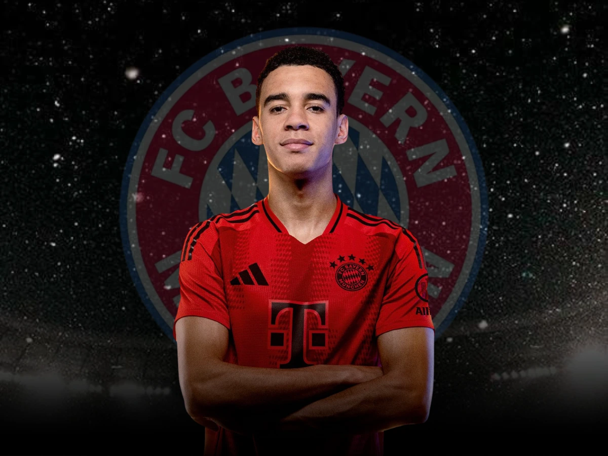 Jamal Musiala in the FC Bayern Munich kit, with the team logo prominently displayed behind