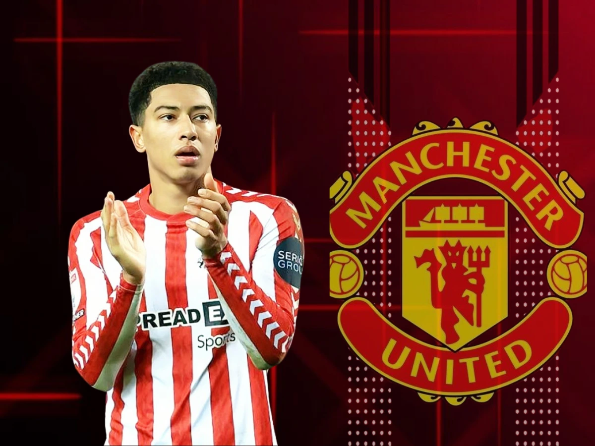 The image features English footballer Jobe Bellingham in a red and white striped Stoke City jersey, clapping. In the background, the Manchester United logo is prominently displayed, suggesting transfer speculation linking him to the club.