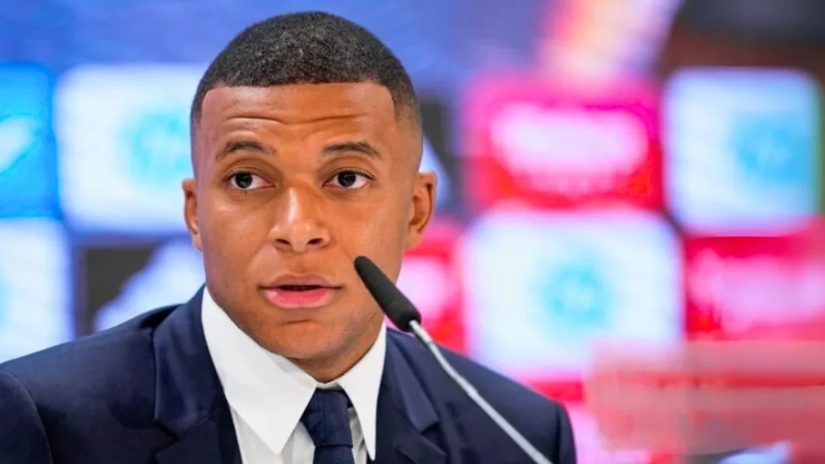 Kylian Mbappé holds up the Real Madrid kit at his official presentation.