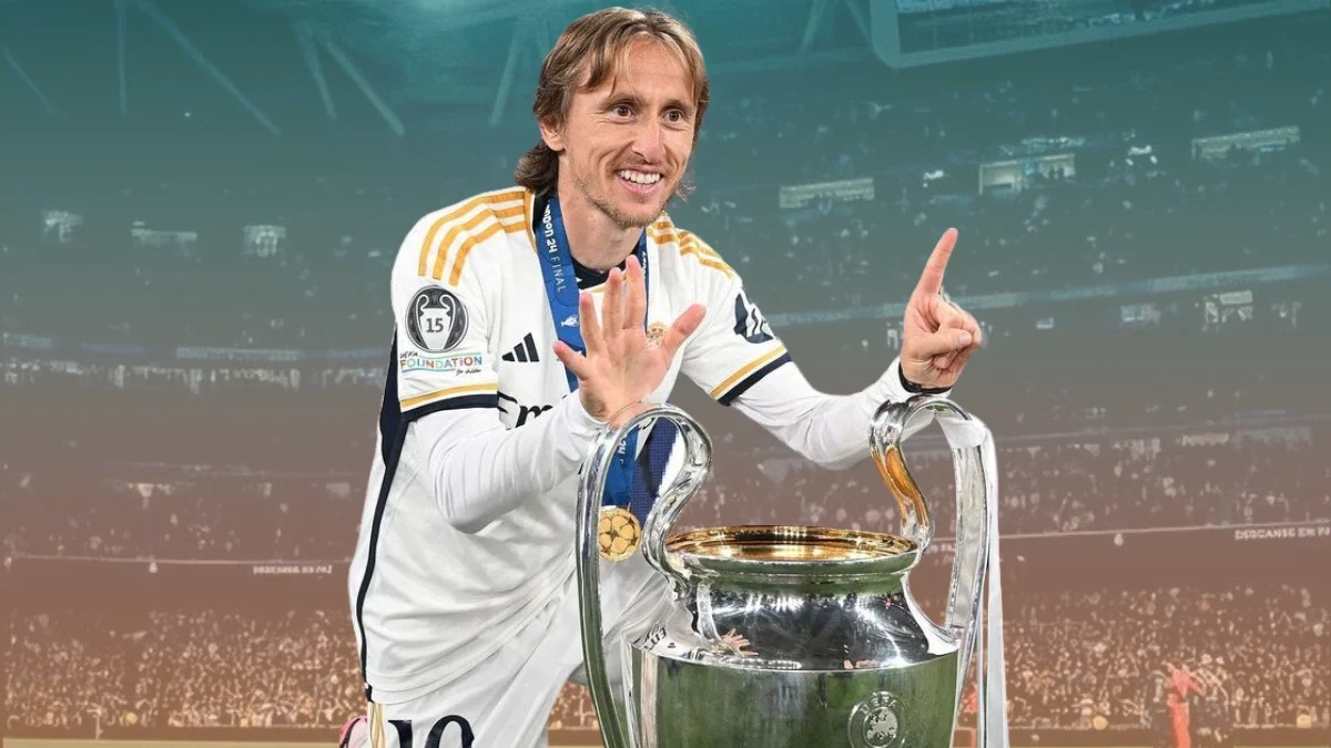 Luka Modrić celebrates with the Champions League trophy, holding up six fingers to mark his titles.